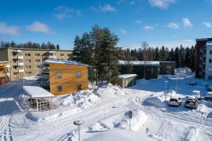 吕勒奥Consultant's Luleå Hub: Work & Rest的积雪覆盖的城市,有建筑物和汽车
