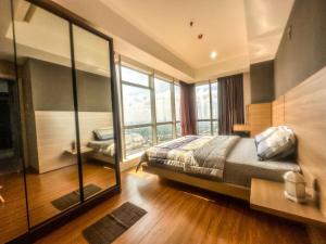 泗水Grand Sungkono Lagoon Apartment 2BR Surabaya by Le Ciel Hospitality的一间卧室设有一张床和一个大窗户