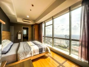 泗水Grand Sungkono Lagoon Apartment 2BR Surabaya by Le Ciel Hospitality的一间卧室设有一张床和一个大窗户