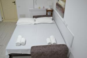 伏罗拉Seaview Penthouse Terrace & Garage的一张带两把椅子的白色床和毛巾