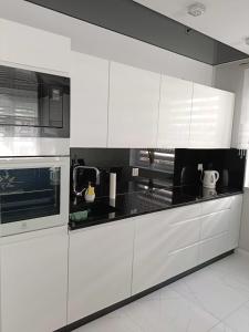 弗罗茨瓦夫Apartament Zielony Zakątek Wrocław的厨房配有白色橱柜和炉灶烤箱。