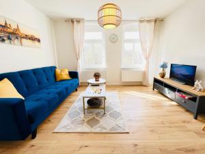 海德瑙Twenty Five Apartment的客厅配有蓝色的沙发和电视