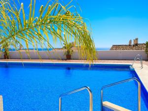 内尔哈Villa Las Brisas by Interhome的一座拥有蓝色海水和棕榈树的游泳池