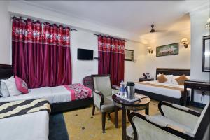 新德里Hotel By Yellow Revels Plum的酒店客房设有两张床和一张桌子。