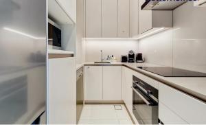 迪拜Address Beach JBR Apartment的白色的厨房配有白色橱柜和水槽