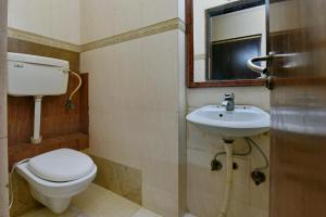 新德里Hotel By Yellow Revels Plum的一间带卫生间、水槽和镜子的浴室