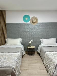 维多利亚-加斯特伊兹Apartamento Kalea corazón urbano的卧室配有两张床,墙上挂着一顶帽子