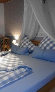 ArzfeldFerienwohnung Kribs的一张带蓝色和白色床单及枕头的床