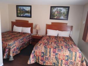 科灵伍德Relax Inn-Collingwood的酒店客房设有两张床和两盏灯。