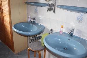 ArzfeldFerienwohnung Kribs的一间带蓝色水槽和凳子的浴室