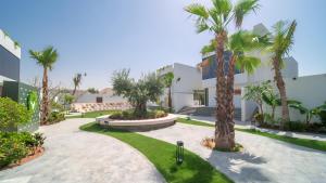 迪拜Nas House Private Villas的棕榈树庭院和建筑