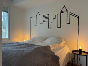 卡里纳Uusi kaksio autopaikalla的卧室配有一张床铺,墙上挂有城市