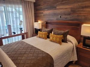 巴拉斯港Hotel Puerta del Lago的一间卧室配有一张带木墙的大床