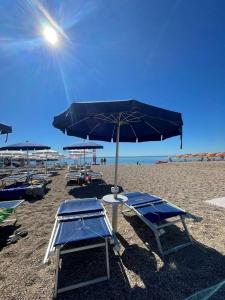努马纳TRILO COPPO CON SPIAGGIA E POSTO AUTO的海滩上的一组椅子和遮阳伞