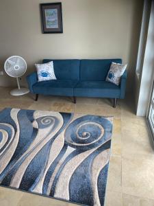 Long SwampTop of the Hill Blue Sunshine的客厅里一张蓝色的沙发,铺有地毯