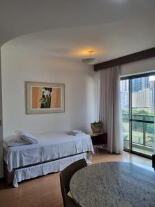 贝洛奥里藏特Flat Pancetti的酒店客房设有一张床和一个大窗户
