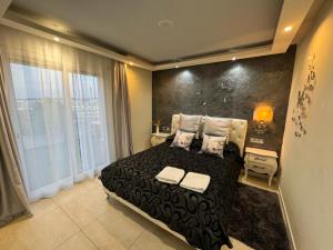 萨洛Apartamento Amposta的一间卧室设有一张黑色的床和一个大窗户