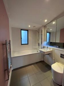 伦敦Stay in Style: Modern 2-Bed In Trendy London Area的带浴缸、卫生间和盥洗盆的浴室