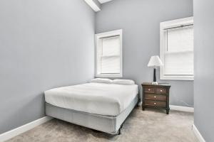 斯普林菲尔德Lovely 2-Bedroom Unit in Springfriend的一间白色卧室,配有床、床头柜和2扇窗户