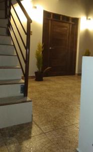 波托西Apartamento cómodo的走廊上设有楼梯,门上设有盆栽