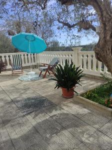 罗卡圣焦万尼Casa vacanze l'Ulivo的配有长凳和蓝伞的围栏