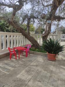 罗卡圣焦万尼Casa vacanze l'Ulivo的树下两把红色椅子和一张桌子