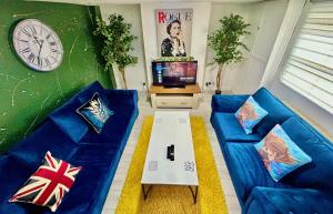 伊普斯威奇6 Bedroom House -Sleeps 12- Big Savings on Long Stays!!的客厅配有蓝色的沙发和电视