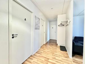 赫尔辛基DownTown Rooms And Sauna的一条带白色门和蓝色沙发的走廊