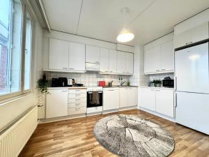 赫尔辛基DownTown Rooms And Sauna的一间厨房,配有白色的橱柜和大窗户