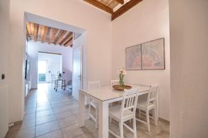 佛罗伦萨San Niccolò Luxury Apartment的白色的用餐室配有白色的桌椅