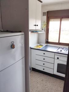 阿尔姆尼卡Room in Shared apartment with Parking的厨房配有白色冰箱和炉灶。
