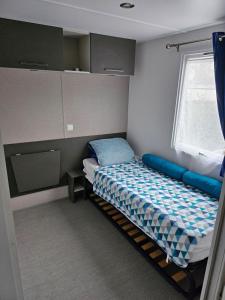 翁赞Assist' Mobil Home 77 - Mobil home 3 chambres 2 salles de bain au calme的一间小卧室,配有床和窗户