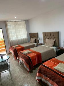 伊察Huacachina Desert House的酒店客房设有两张床和一张桌子。