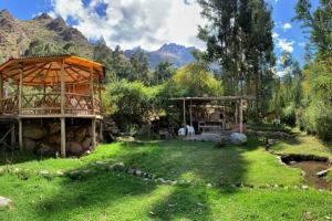 乌鲁班巴Eco Lodge Cabañas con Piscina的绿意盎然的院子,有建筑,树木和山脉