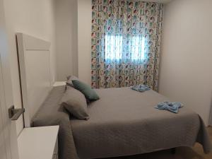 莫哈卡尔Mojacar Luxury的一间卧室配有一张带窗帘的床和窗户