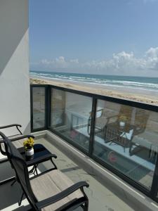 阿夏尔奇亚Sea View Chalet Al Ashkharah的一个带桌椅和海滩的阳台