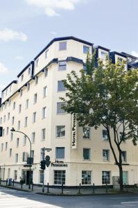 杜塞尔多夫圣彼得堡公寓酒店的前面有一棵树的白色大建筑