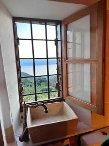 安吉斯乔治亚斯尼拉Magical cottage!的带窗户的浴室内的盥洗盆