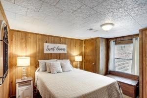 Heber SpringsHeber Springs Cabin with Deck 3 Mi to Sugarloaf Mtn的卧室配有一张床,墙上有标志
