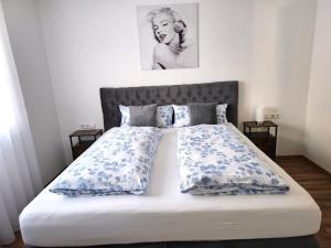 菲林根-施文宁根MY HOME N 35/6的一间卧室配有一张带蓝色和白色枕头的床