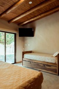 圣拉斐尔Posada Bonarda的一间卧室配有两张床和一台平面电视
