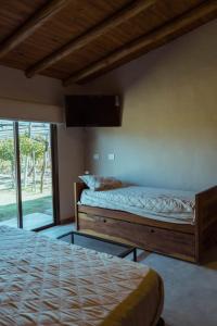 圣拉斐尔Posada Bonarda的一间卧室设有两张床,墙上配有电视。