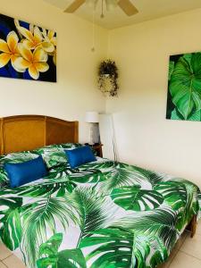 帕皮提Heiata Lodge Papeete的一间卧室配有一张带绿色和白色棉被的床