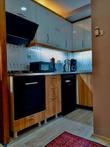 凡城Me Van, outstanding, modern and stylish in the city centre的厨房配有木制橱柜和黑色洗碗机。