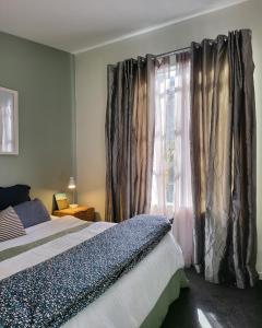 奥克兰Artist Photographers Home Studio的一间卧室配有床和带窗帘的窗户