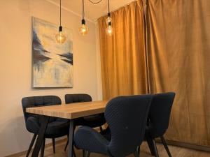 DreiliņiModern 4-Room compact flat with parking in Riga的一间带木桌和椅子的用餐室