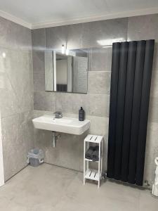 伯肯黑德Rock Lane Rooms的浴室设有水槽和黑色淋浴帘