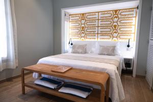 莫雷阿Niu Beach Hôtel Moorea的一间卧室配有一张带木制床头板的床