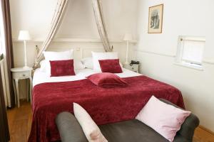 维里坎皮尔萨托伦旅馆的一间卧室配有一张带红色毯子的大床