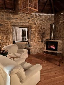 维亚纳堡QUINTA DO CAMBEIRO的客厅配有白色椅子和壁炉